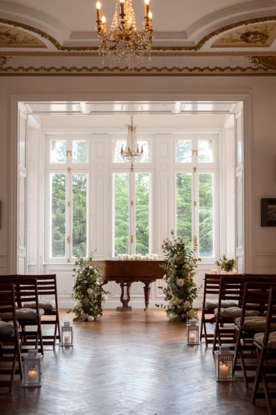 Piano forte in elegant manor house room ceremony setting wooden chairs